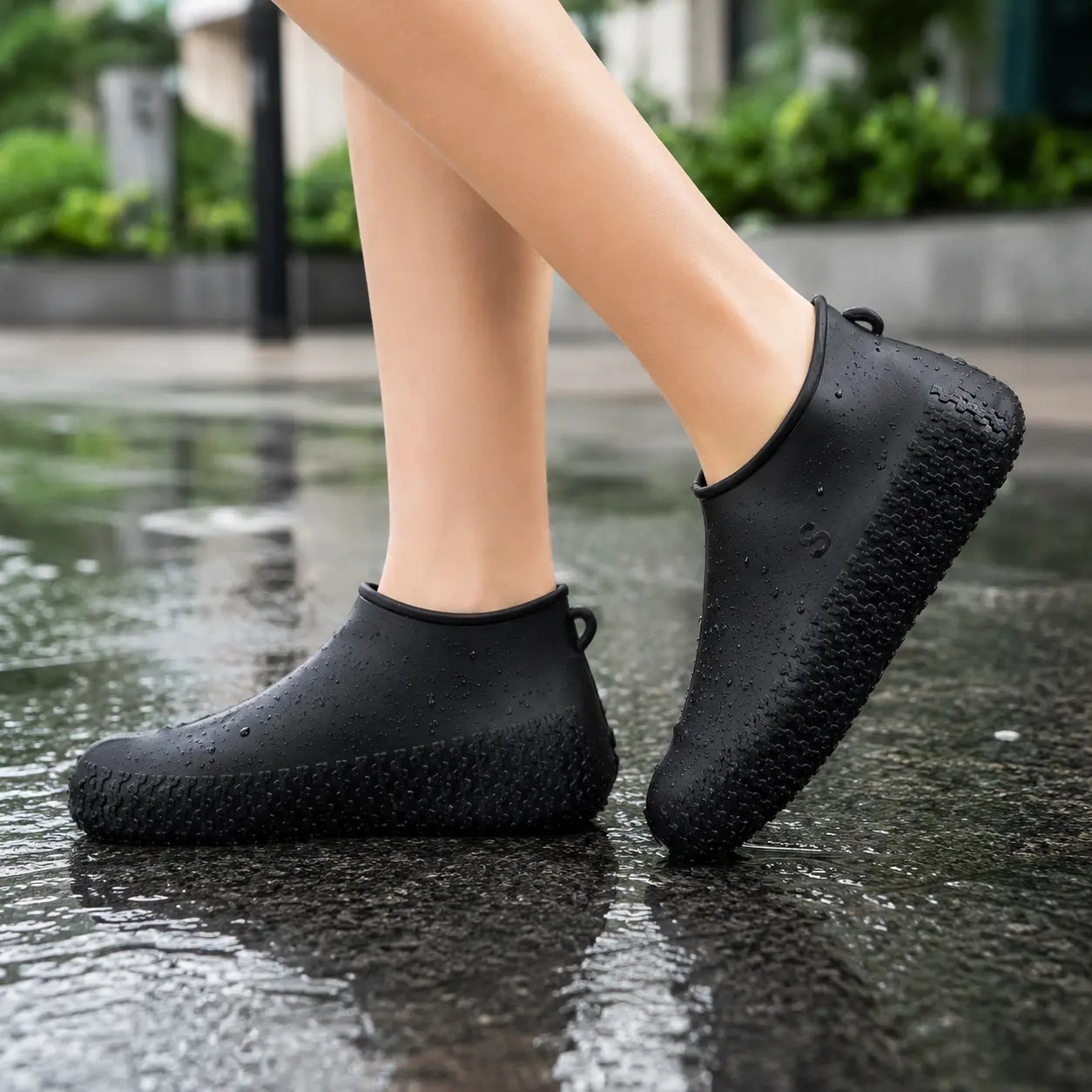 Model Wearing Black Silicone Waterproof Shoe Covers Over Shoes with Non-Slip Reusable Waterproof Design