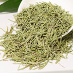 Hand holding pure, chemical-free dried rosemary leaves, emphasizing the organic and high-quality material.